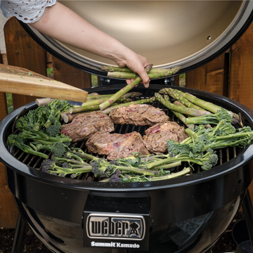 An Image of Lo&Slo cooking meat and veggies on their Weber BBQ