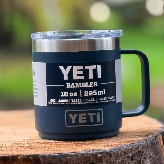 YETI Rambler mug on a wooden surface with a blurred green background