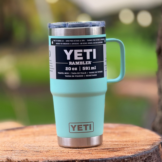 Light blue YETI mug on a wooden surface with a blurred natural background