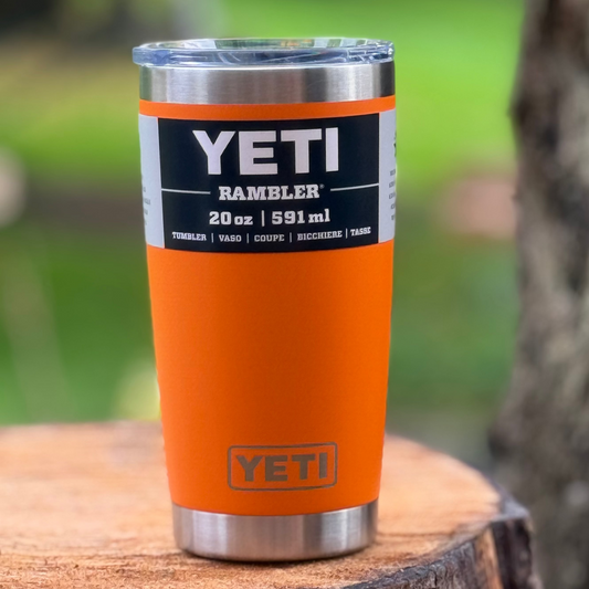 Orange YETI tumbler on a wooden surface with a natural background