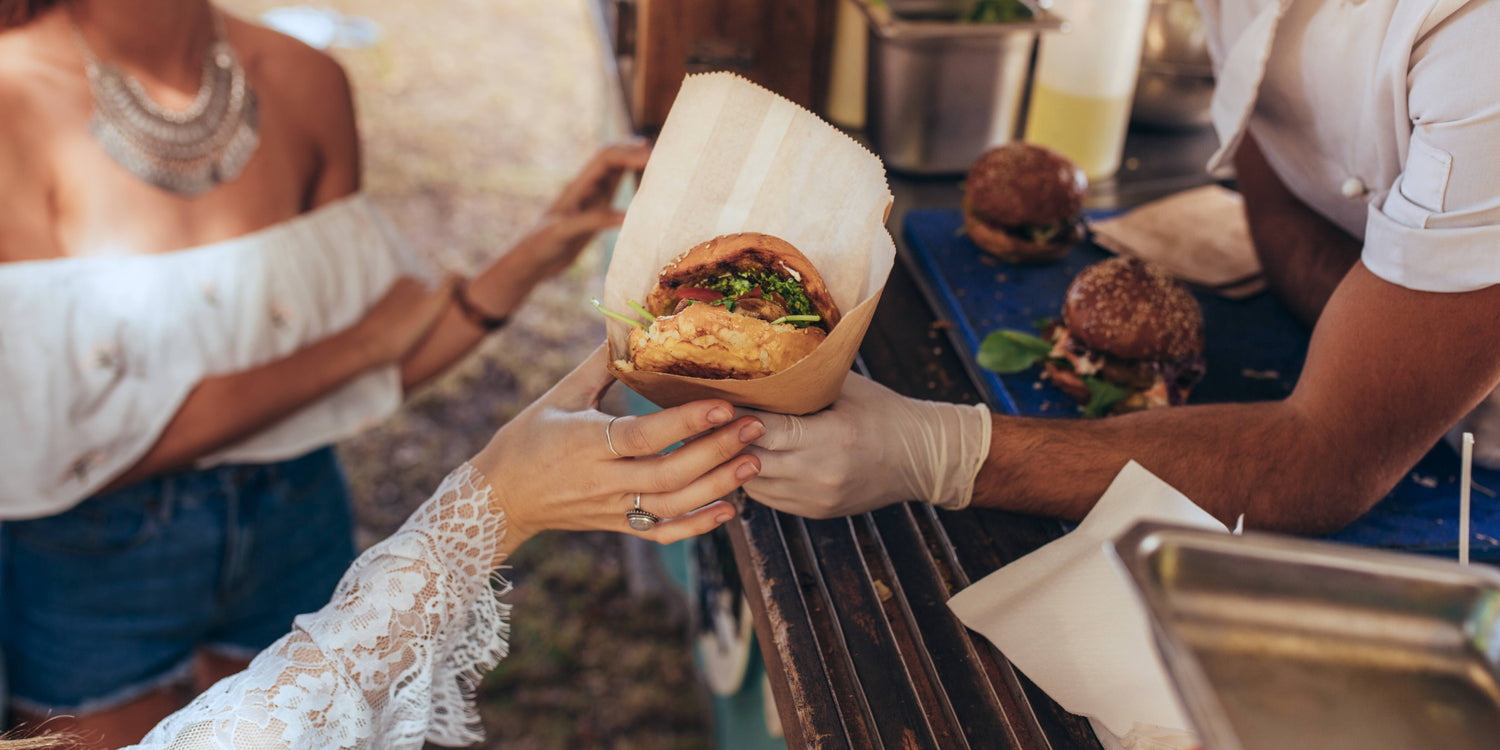 Showing a guest being given food from Lo&Slo's Raptor Food Truck