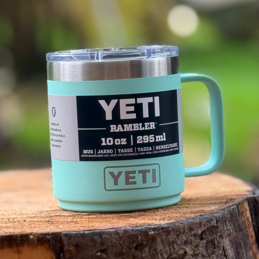 YETI mug on a wooden surface with a blurred green background